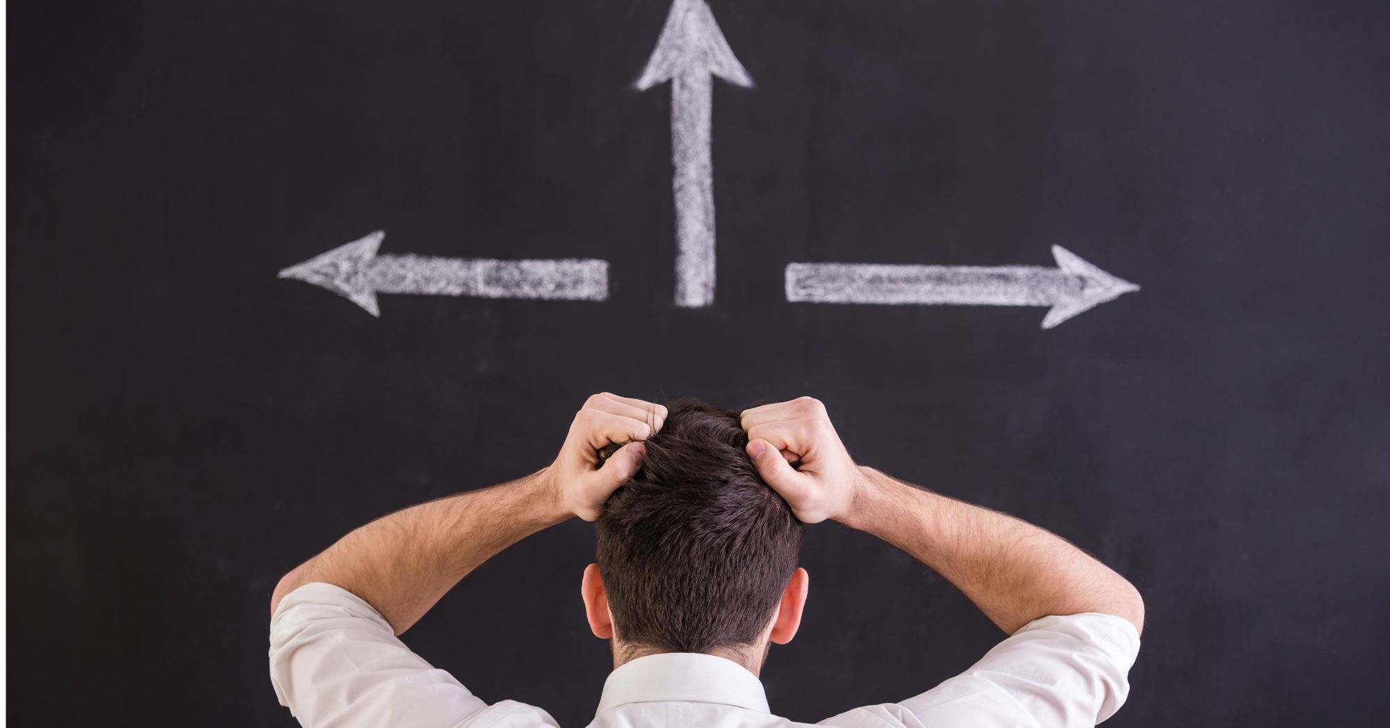 Stressed out and confused man looking at multiple arrows on a black board