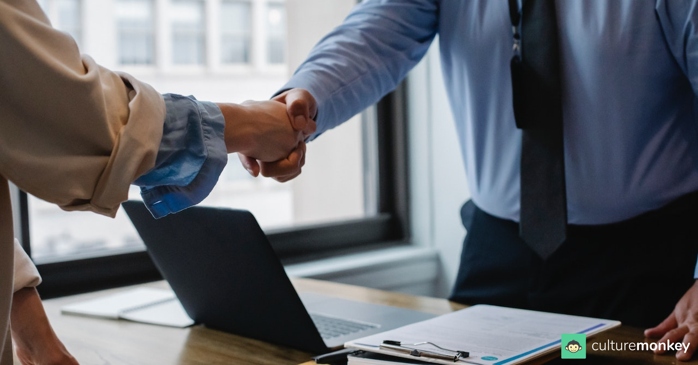 Employer is shaking hands with employee in the workplace