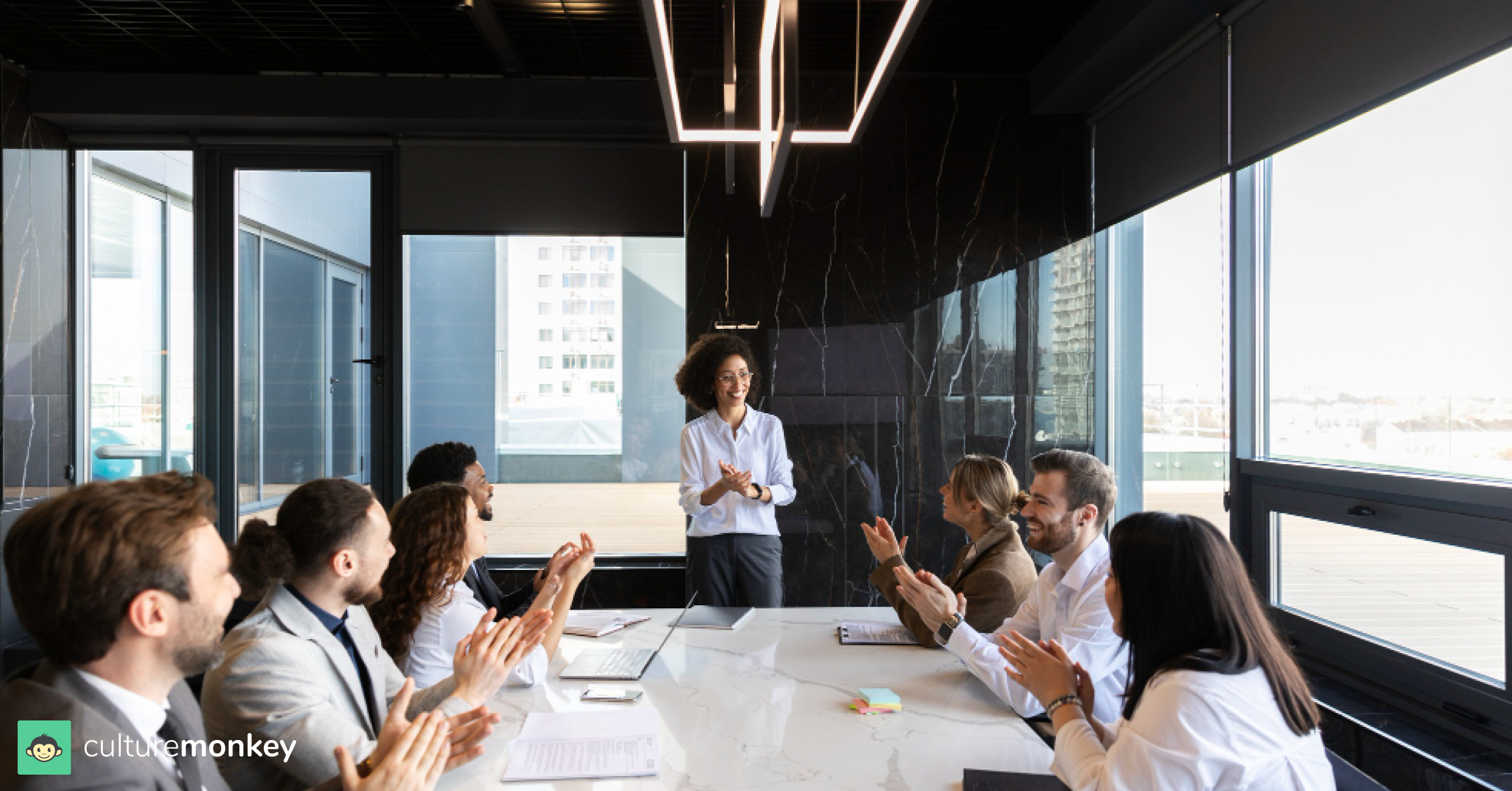 Employees and an employer clapping hands in a meeting