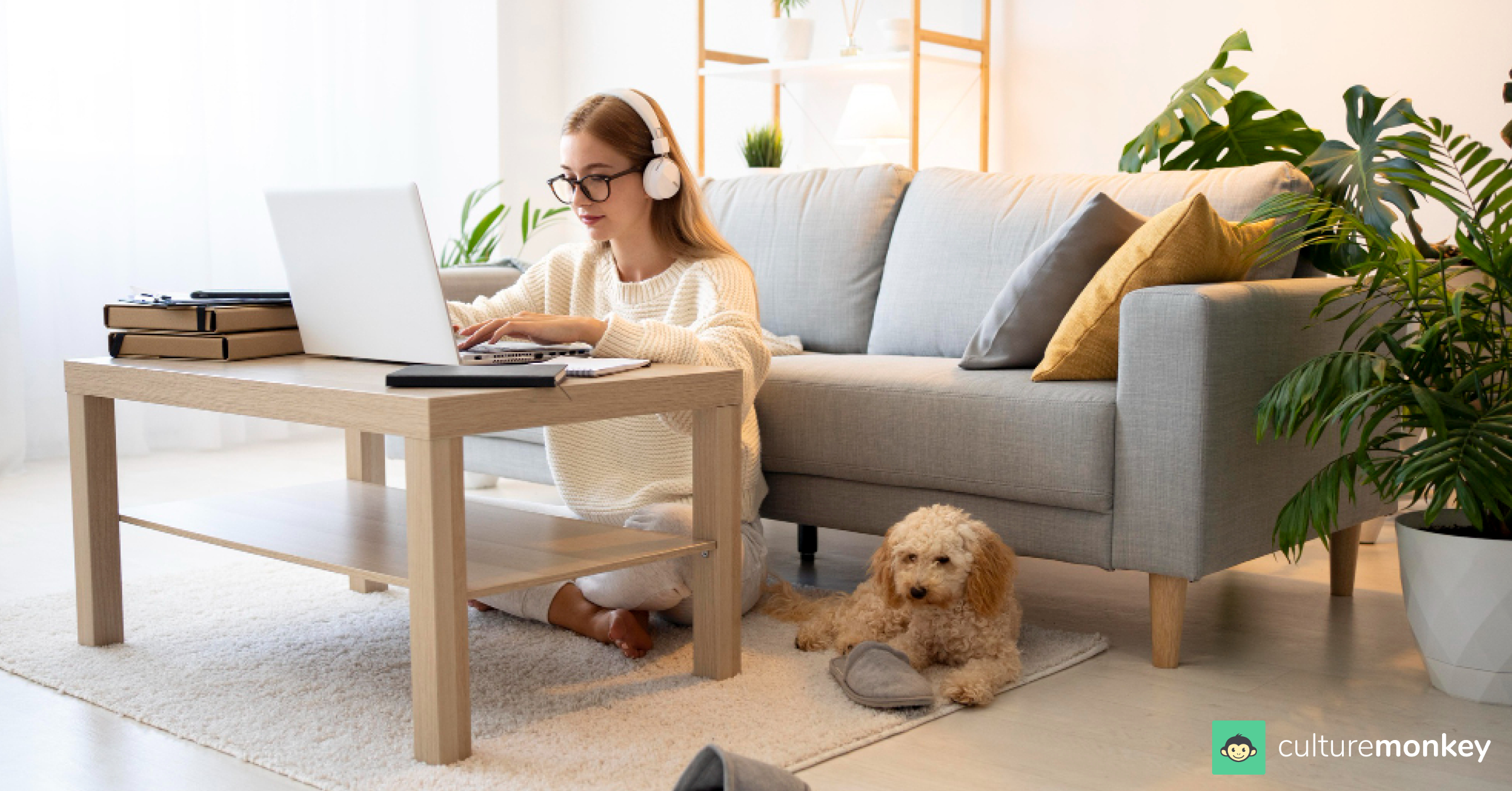Employee is working remotely on the lap, with a dog sitting on the side