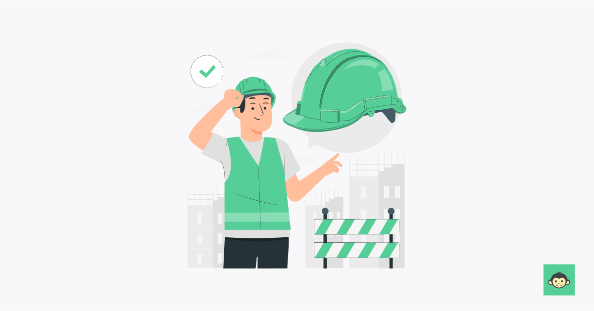 Employee wearing a hard helmet and pointing towards a giant one
