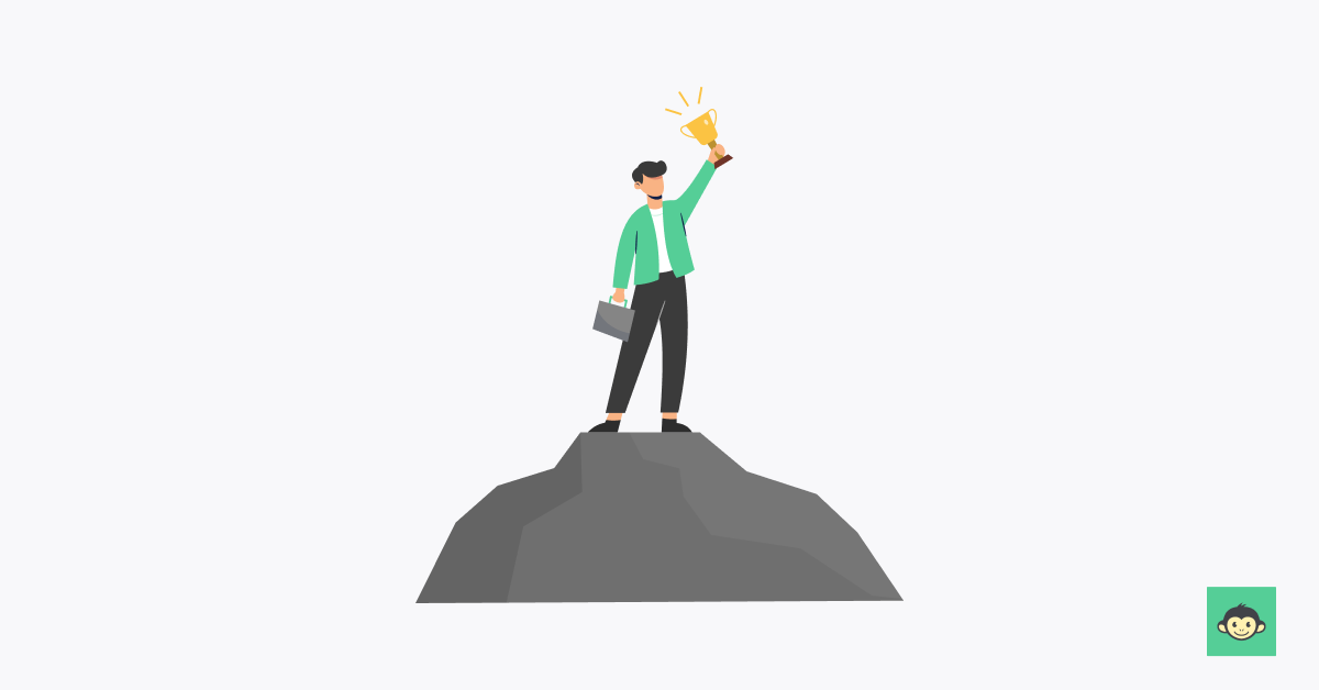 Employer standing on top of a rock while holding a cup high