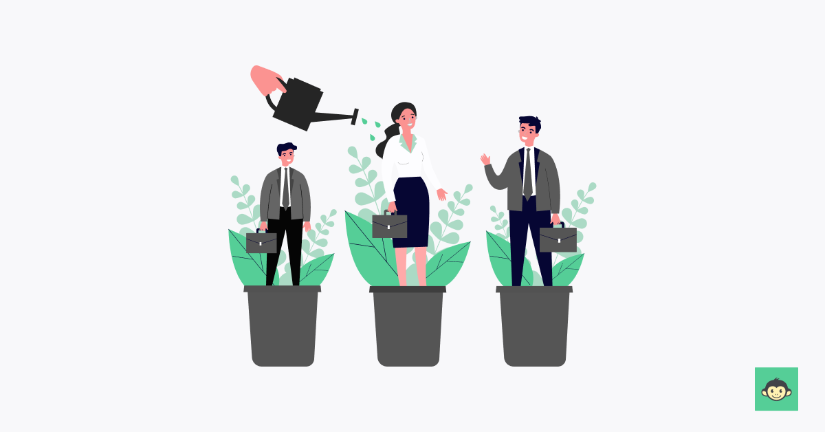 A hand watering employees who are standing in a plant pot