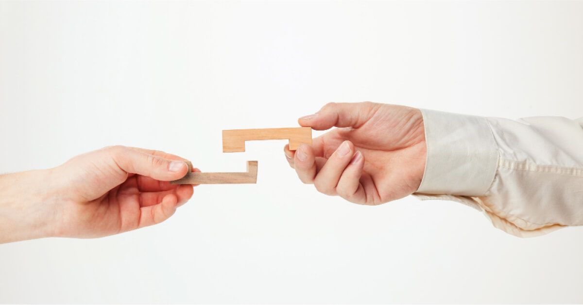 Two hands connecting the puzzle piece