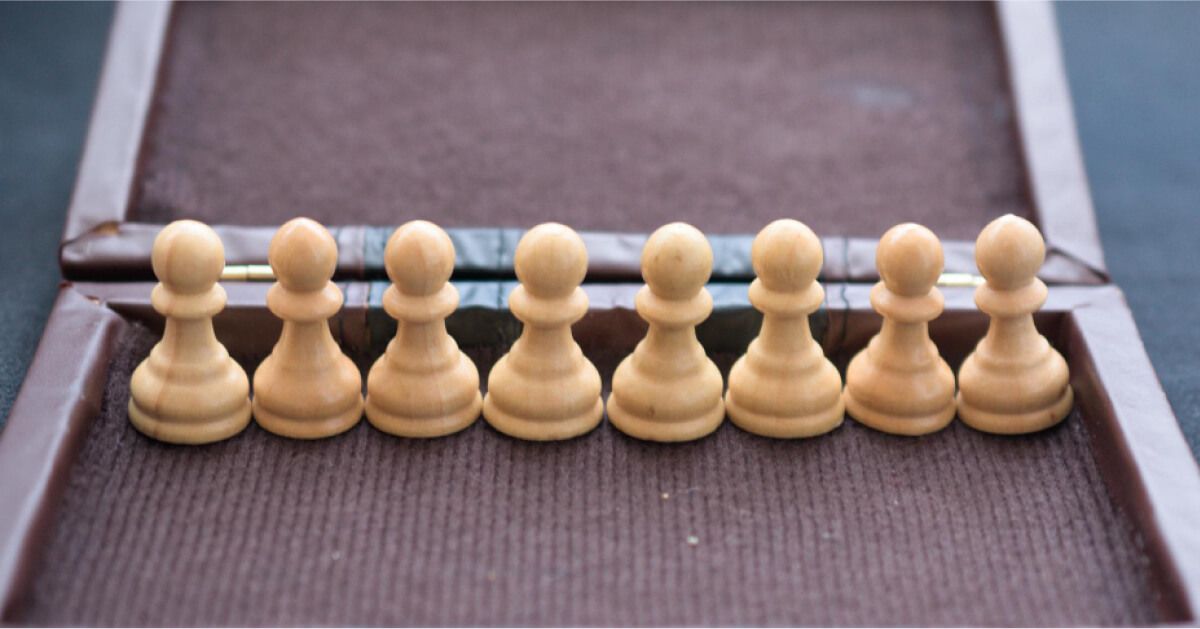 A group of chess pawns arranged in a line