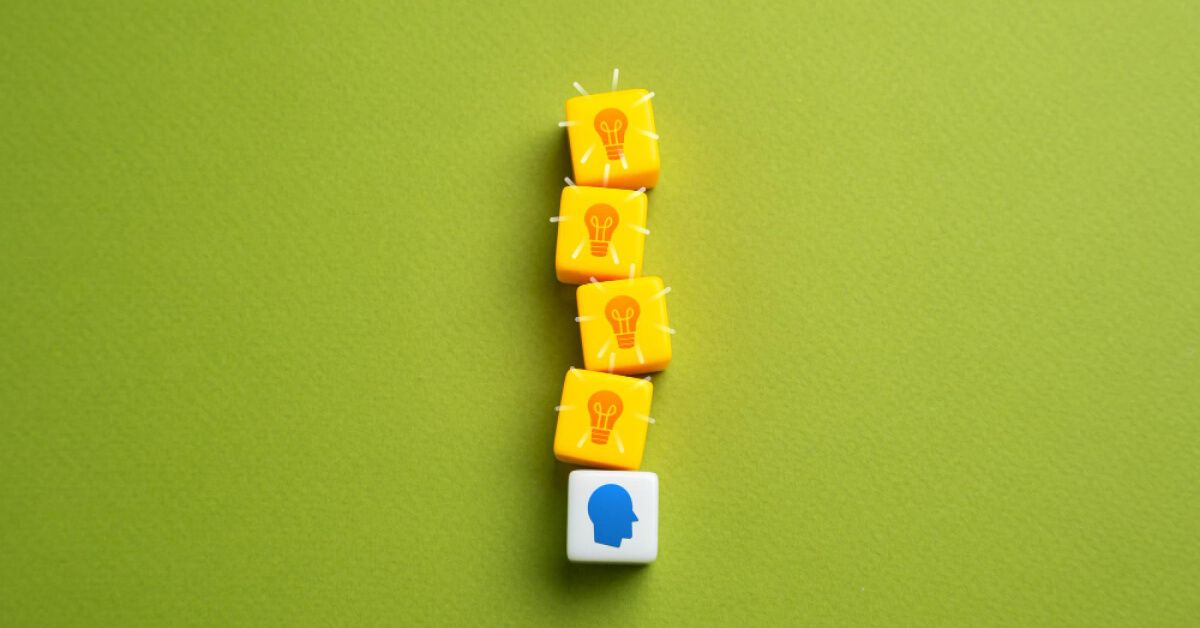 A set of yellow blocks with a lightbulb graphic arranged over a block with a blue human graphic
