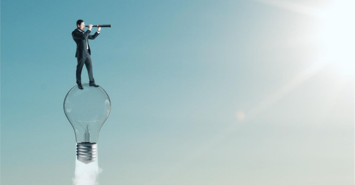Surrealistic shot of a businessman using a telescope on top of a rocketing lightbulb