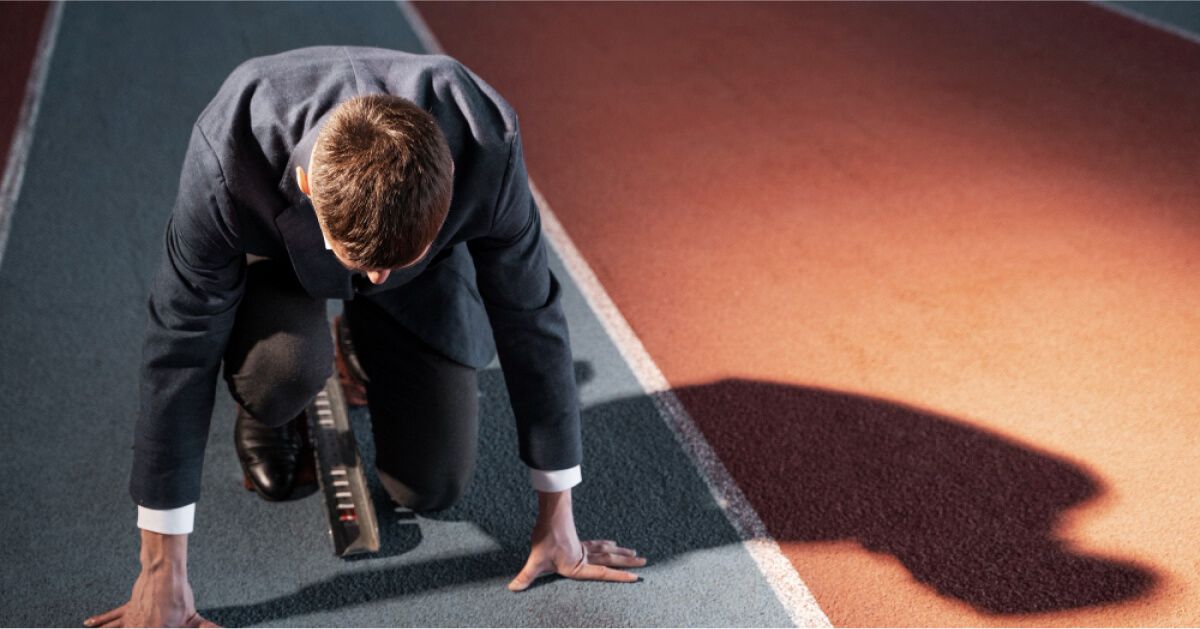 A man in office wear prepared to run