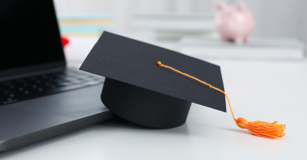 A graduation hat next to a laptop