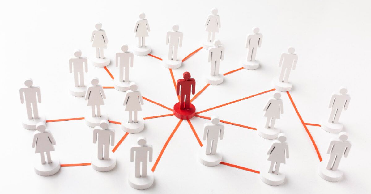 A red human figurine in a network of white figurines