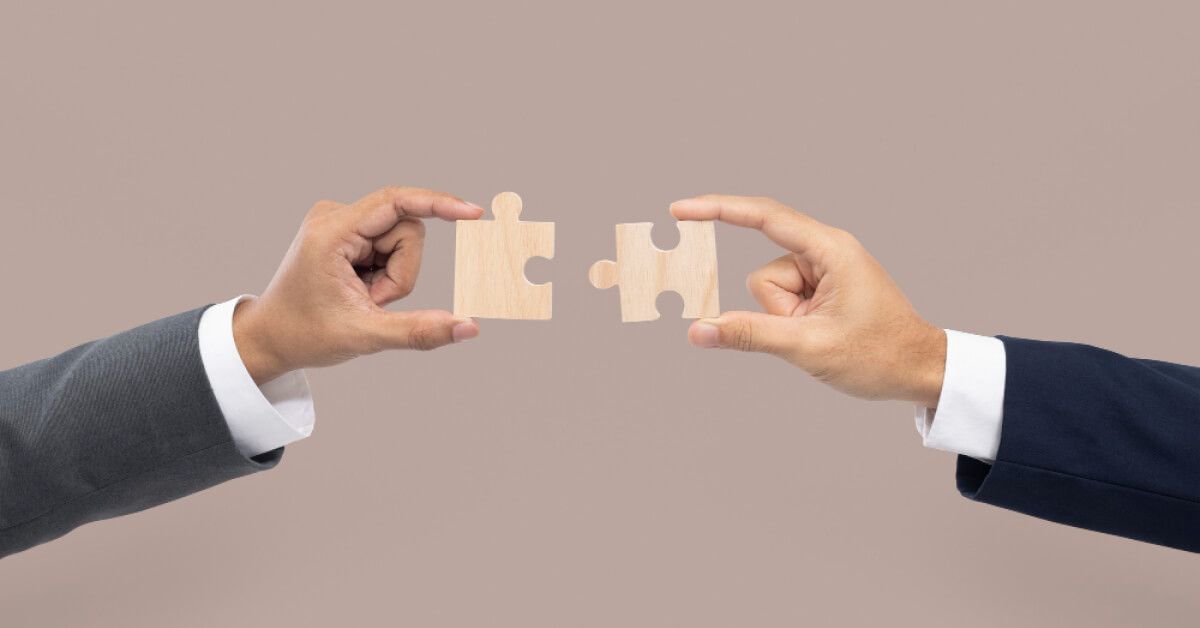 People piecing together wooden puzzle pieces