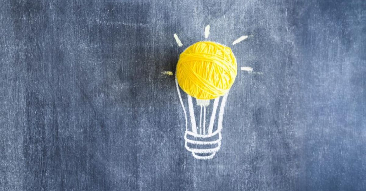 A ball of yellow thread on a chalked lightbulb