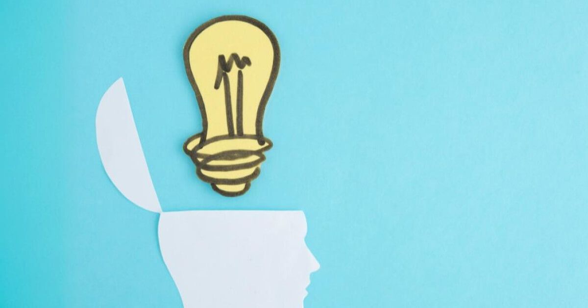 Cutout of a lightbulb over an open paper head