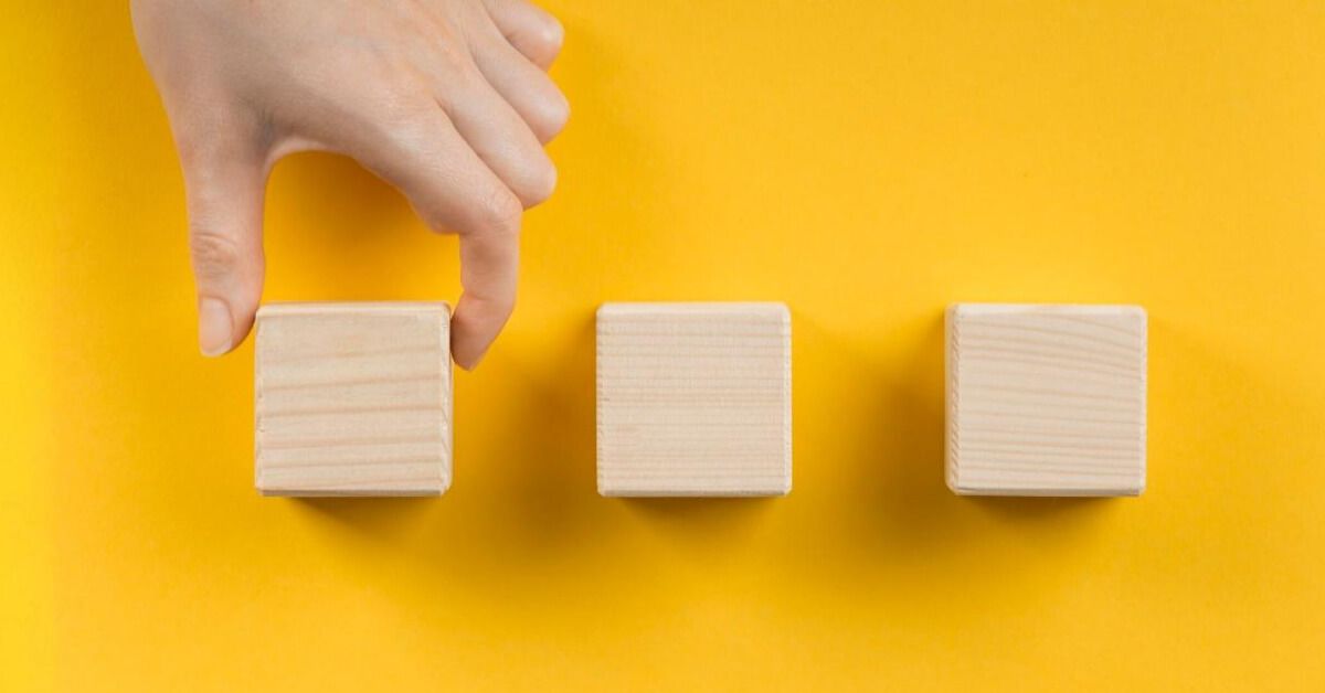 Person picking a wooden block out of a series