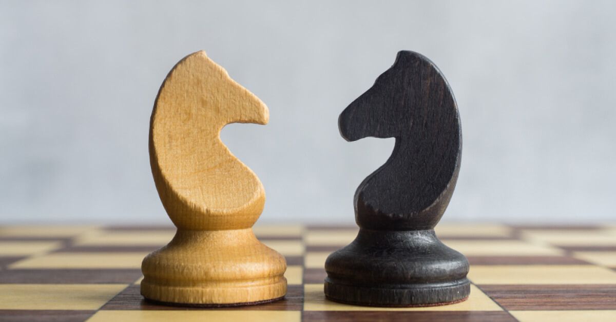Black and white chess pieces facing each other