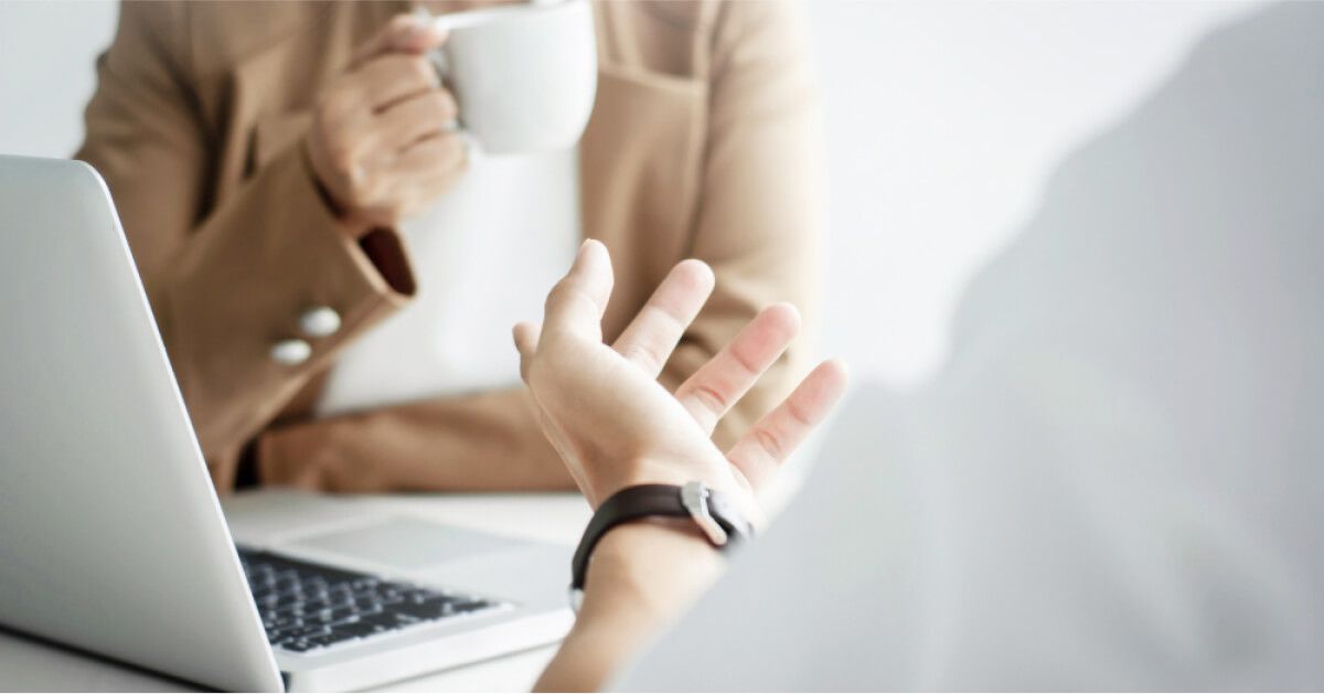 Two people in discussion around a laptop