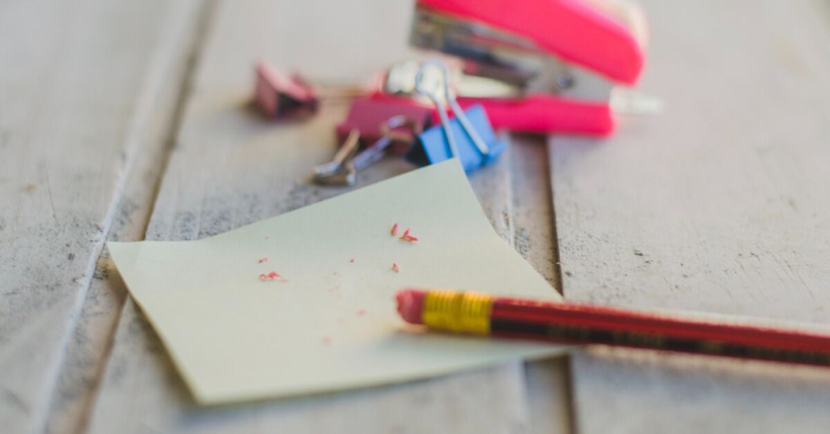 Pencil with an eraser end on top of a piece of paper