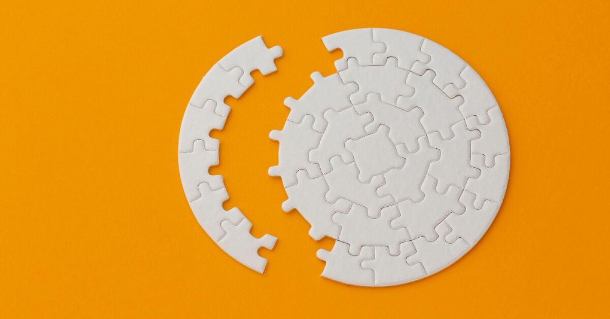 A set of puzzle pieces removed out of a circular white puzzle