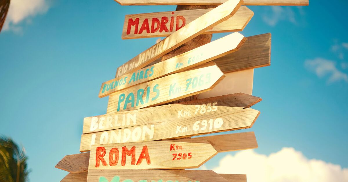 Wooden directional boards with city names on them