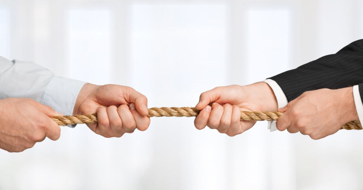 Employees tugging a rope in opposite directions