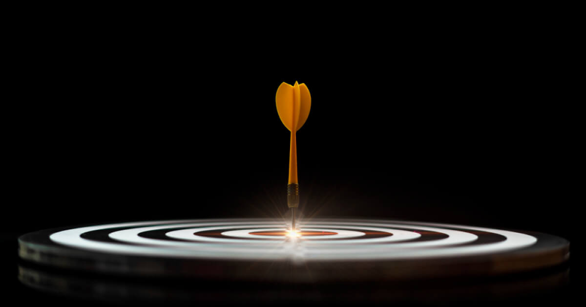 An yellow dart hitting the centre of a target board