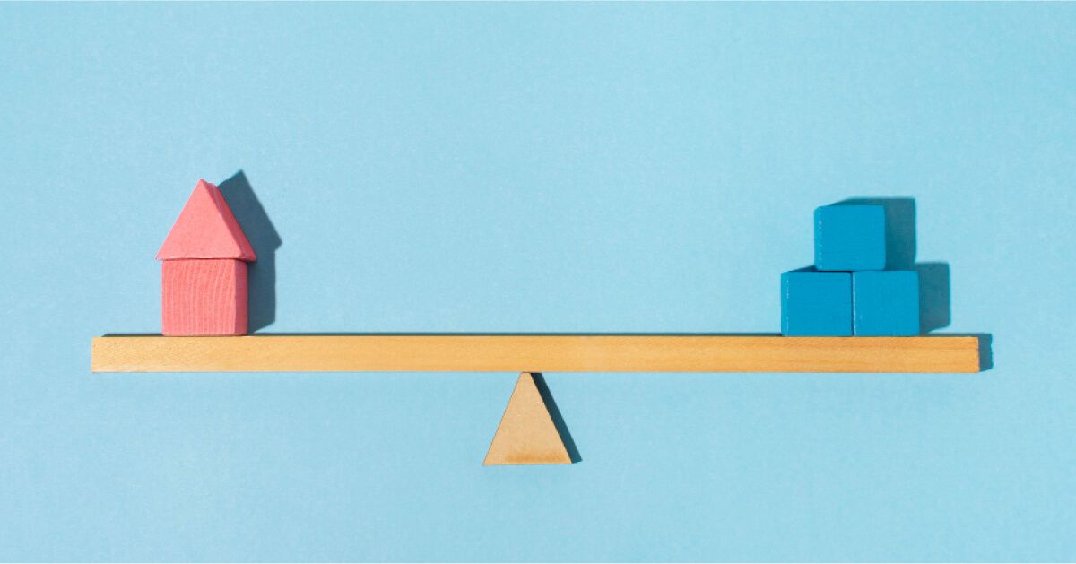 Pink and blue blocks perfectly balanced on a wooden balancing scale