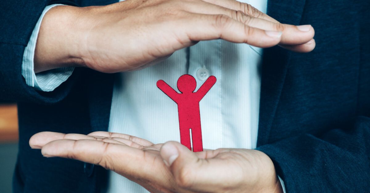 Person holding a red figurine between their palms