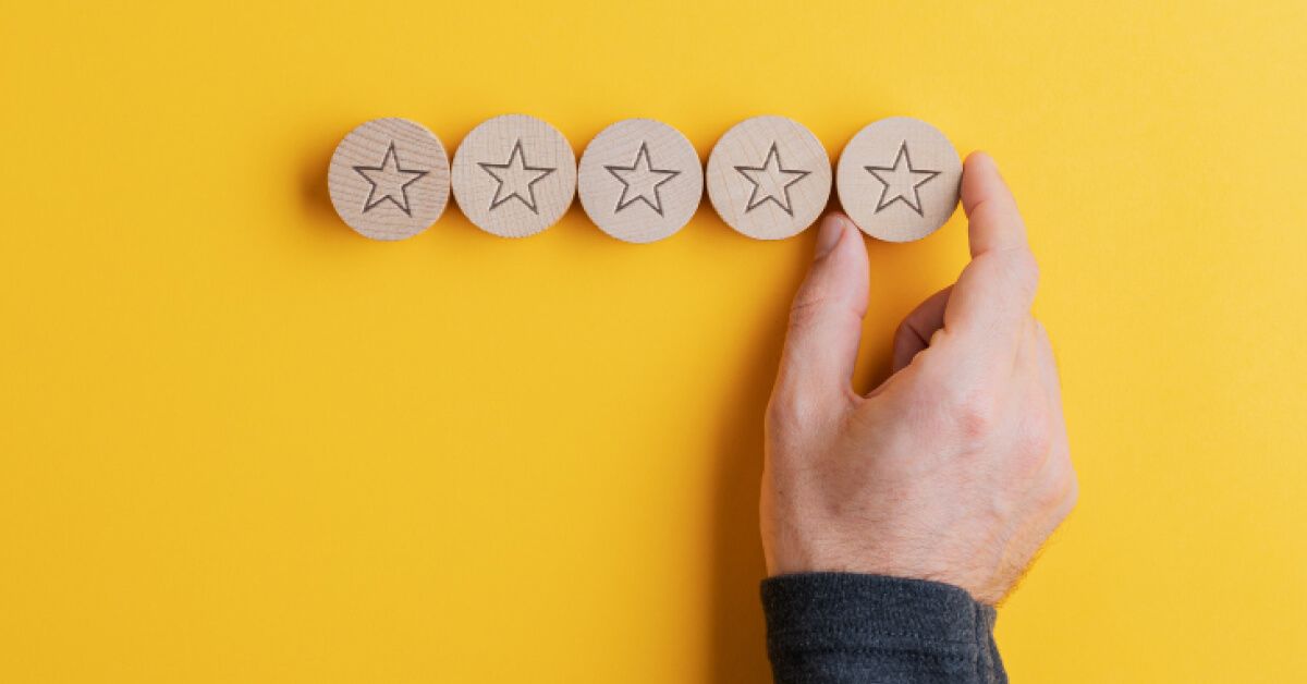 Person placing a wooden chip with a star icon next to a series of other chips