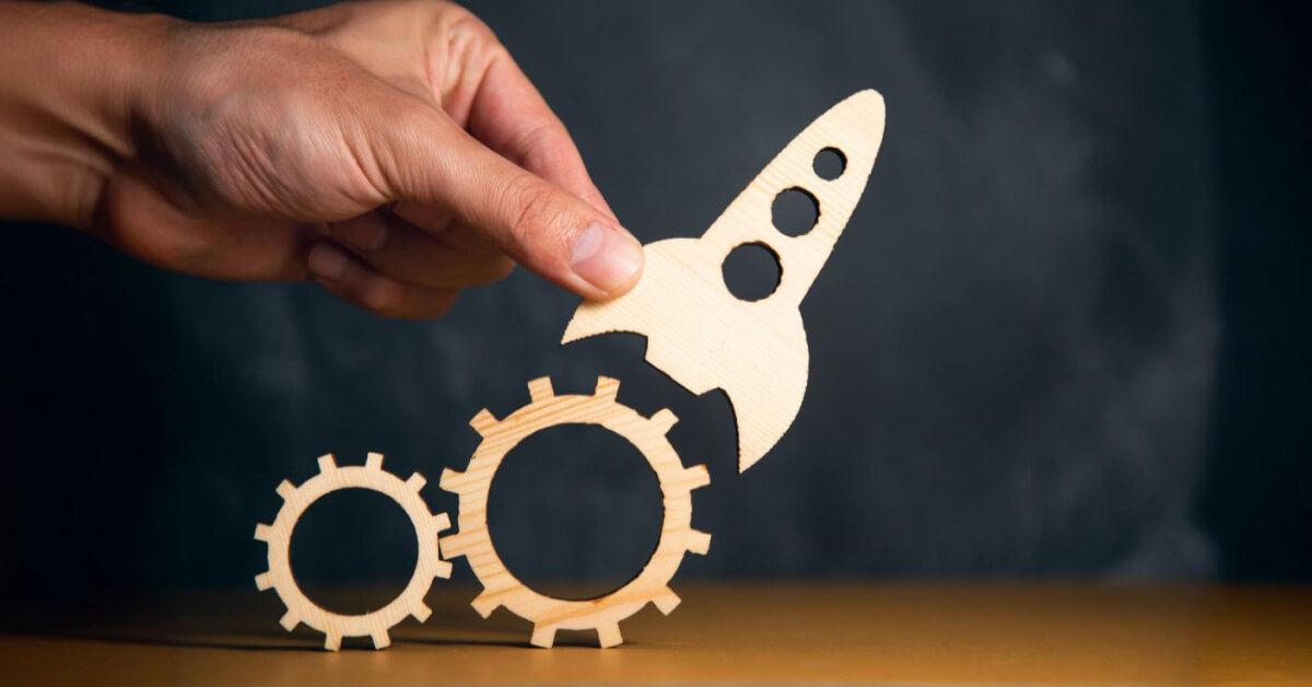 Wooden stencil cutout of a rocket next to a set of gears