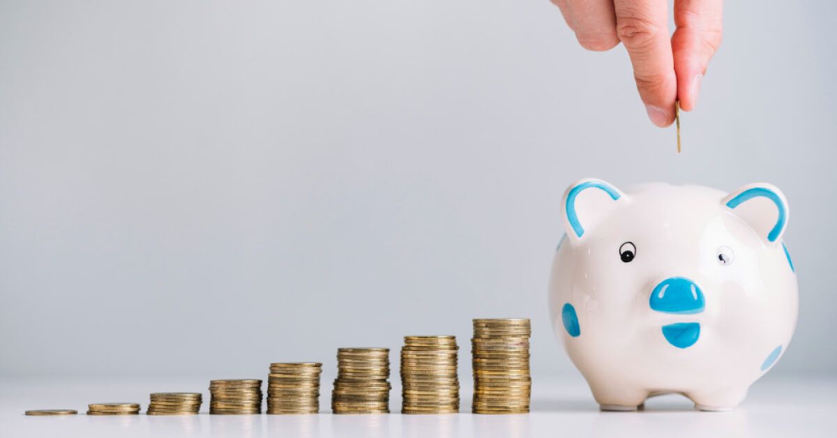 Progressively increasing stacks of coins leading up to a piggy bank