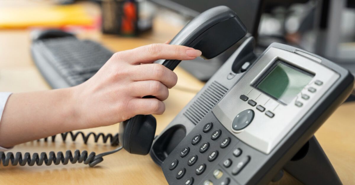 Person picking up a telephone receiver