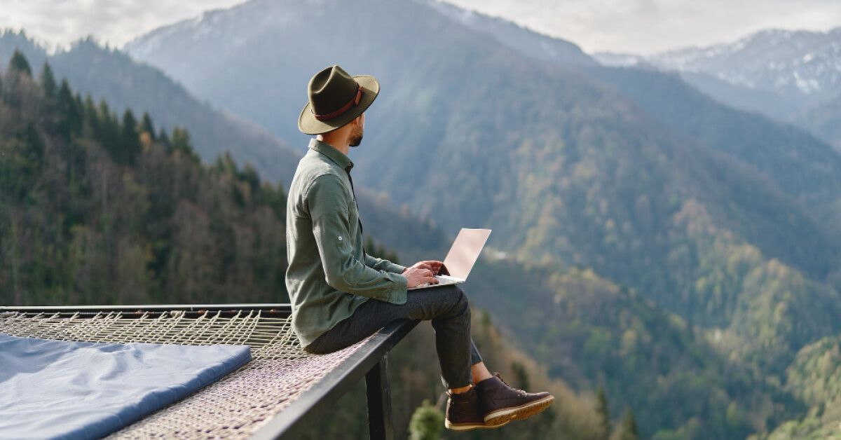 Remote employee working on the edge of a mountain