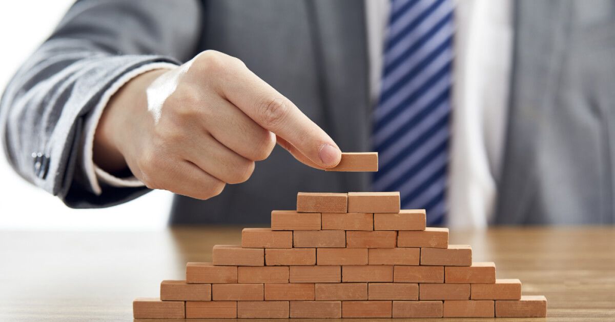 Person placing a block on top of a tower of other blocks