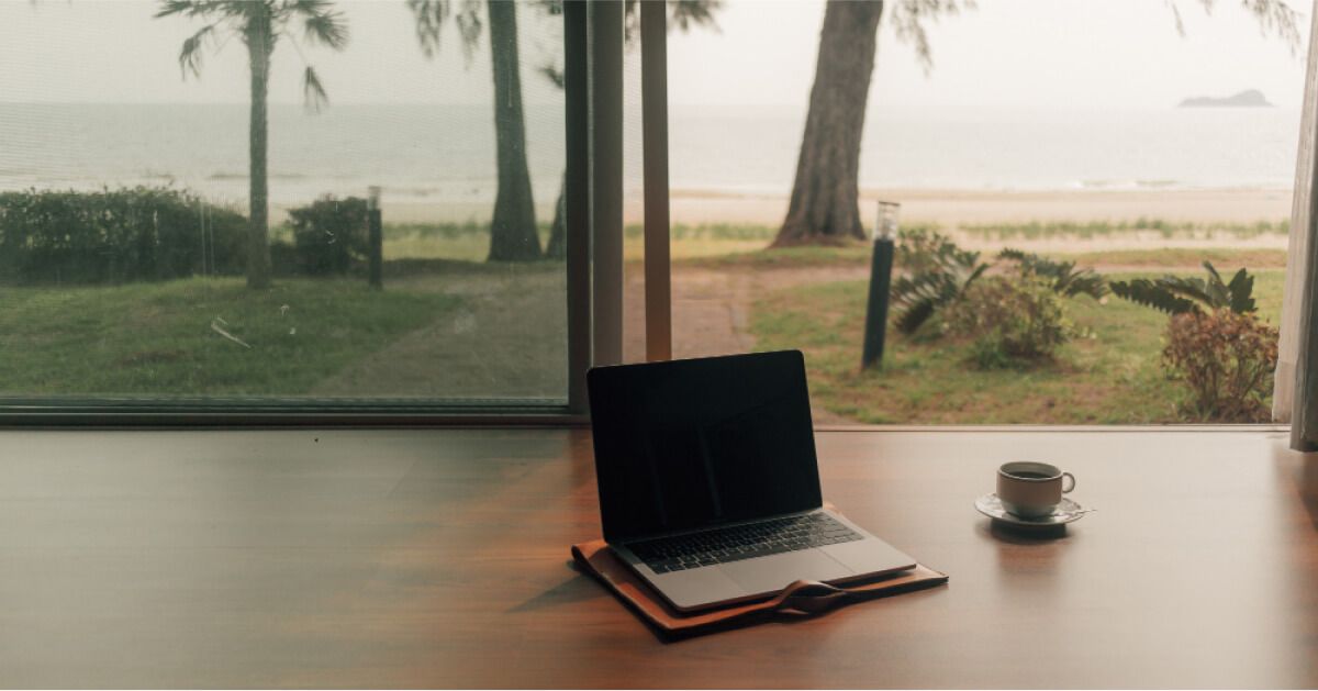 An open laptop in a beachside environment