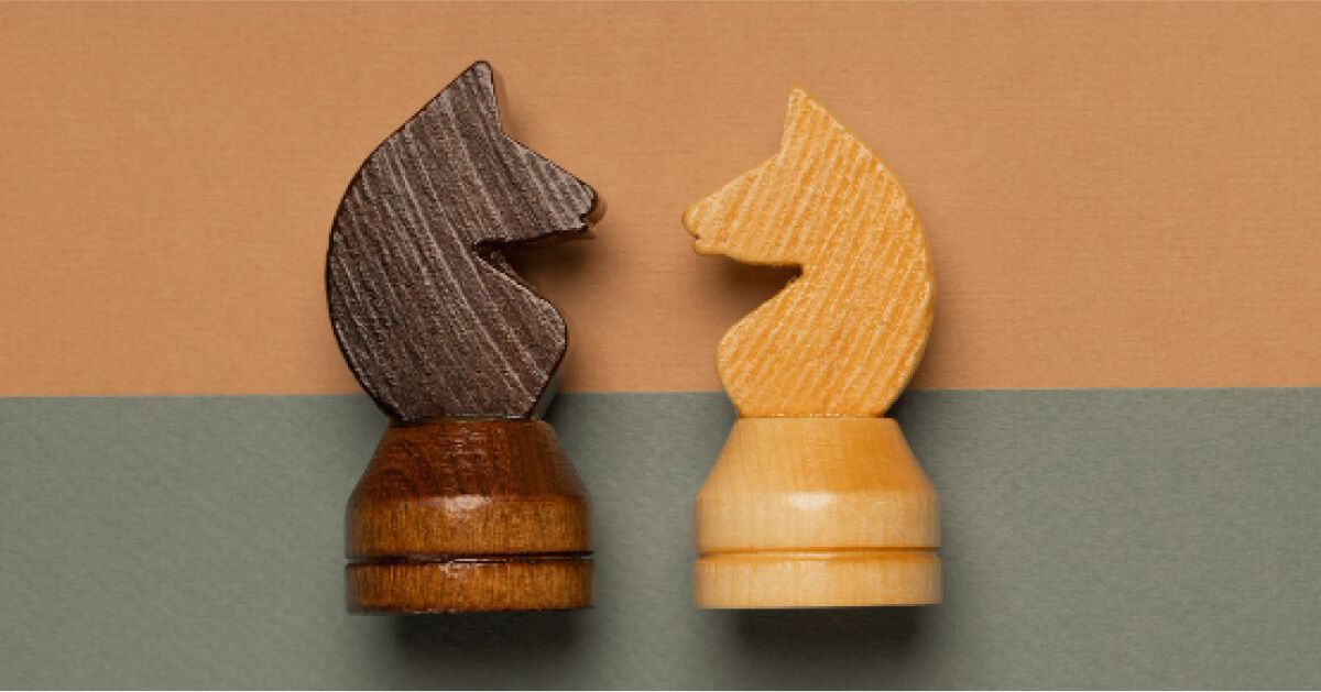 Black and white chess pieces facing each other