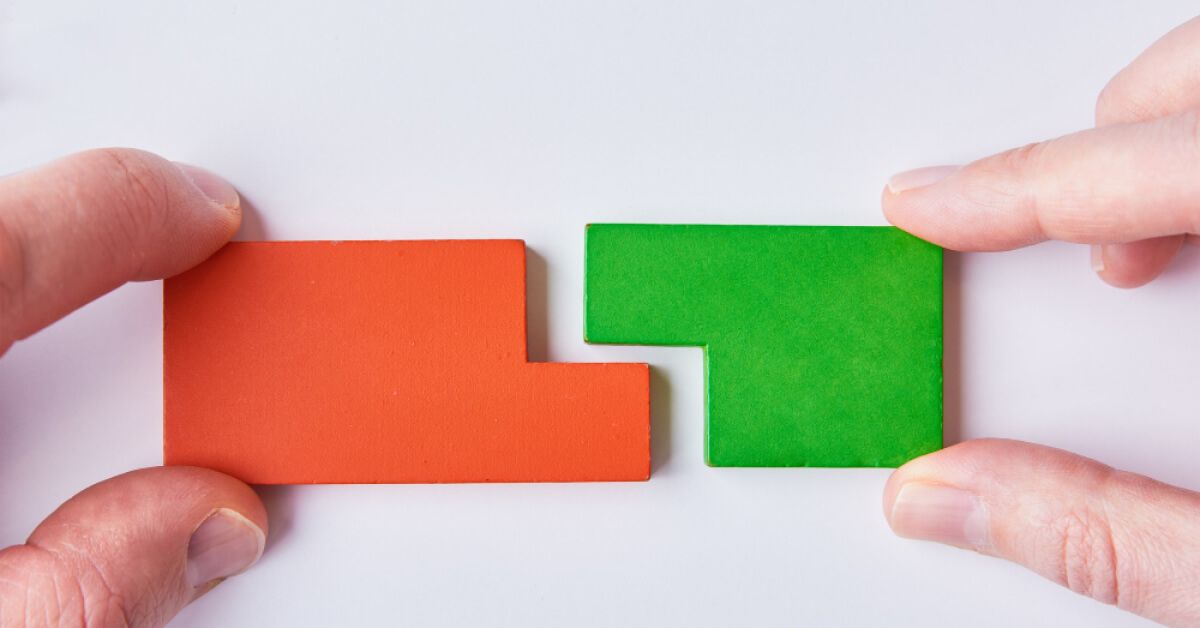 Person joining orange and green pieces together
