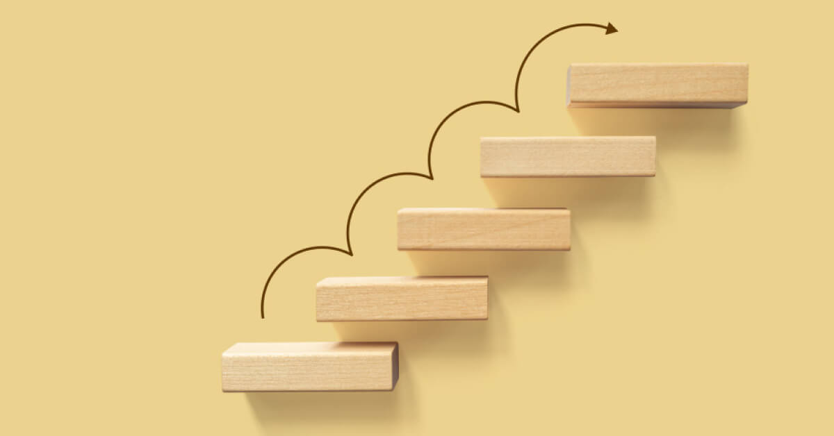 Looping upward arrow on a set of wooden blocks