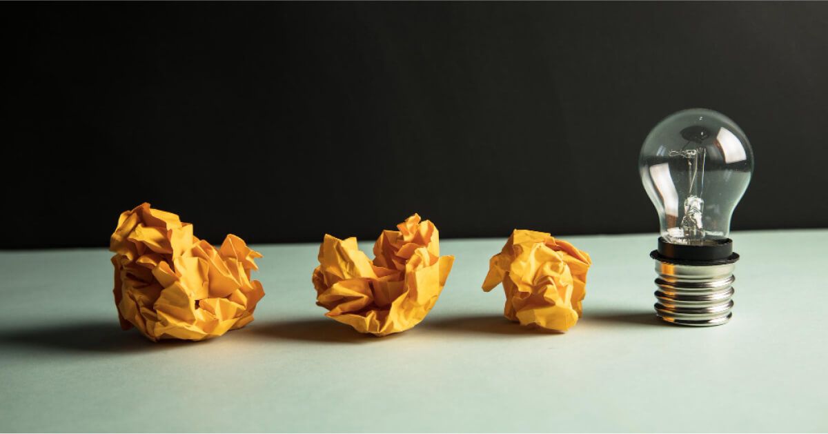Crushed up paper balls next to a lightbulb