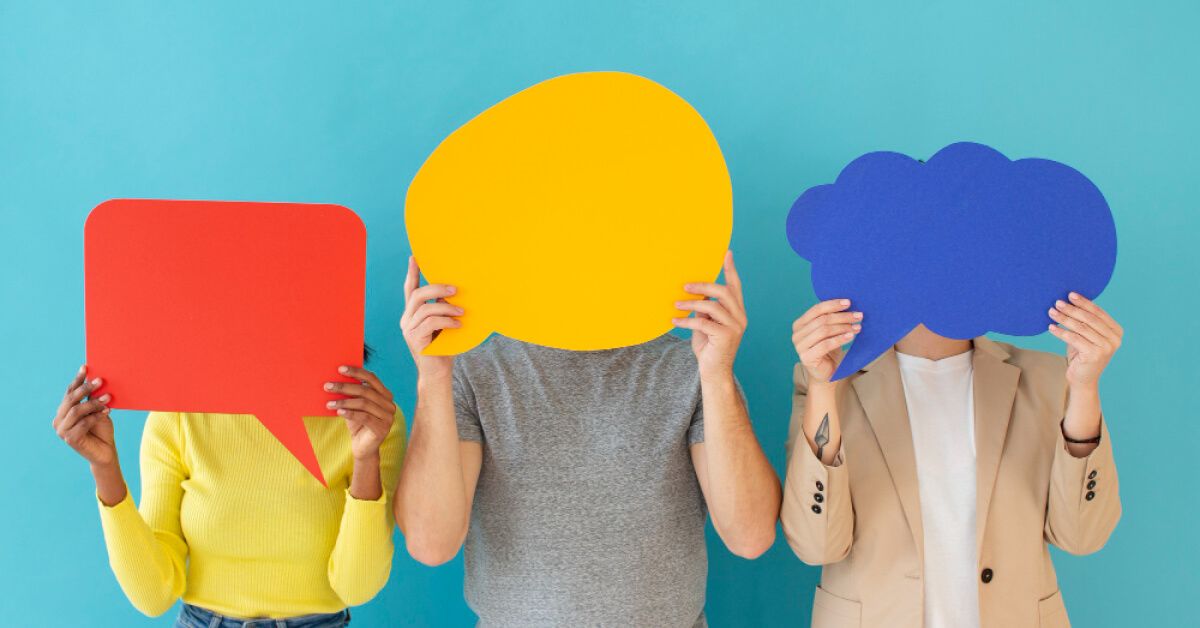 Group of people holding up bright conversation bubbles
