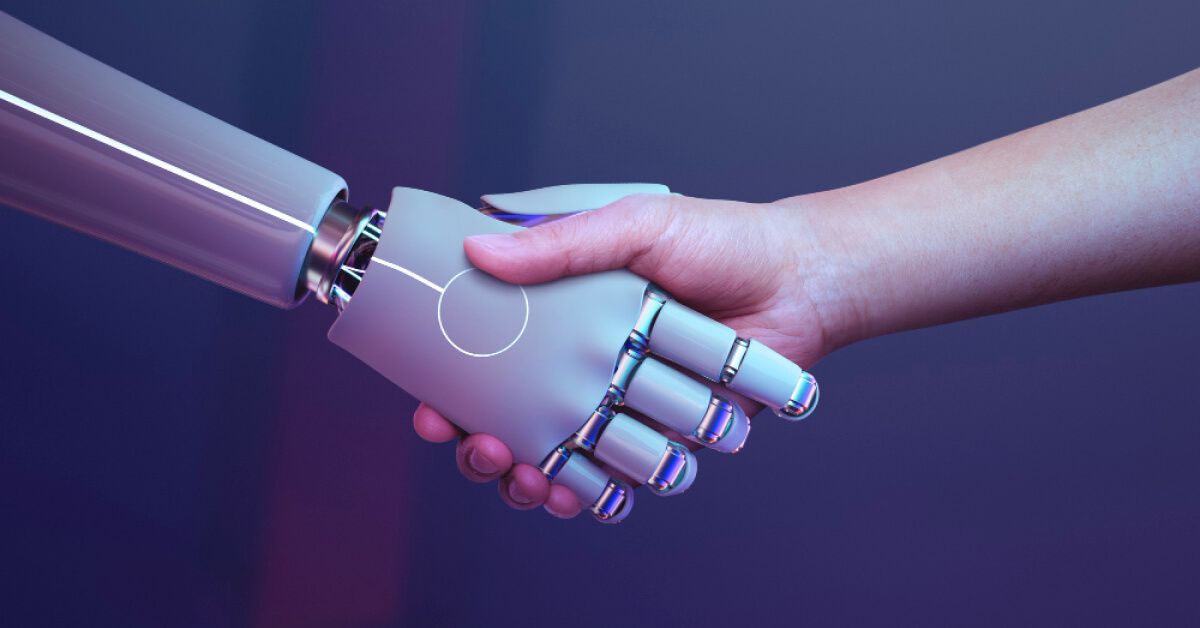 A human hand and a robotic hand participating in a handshake