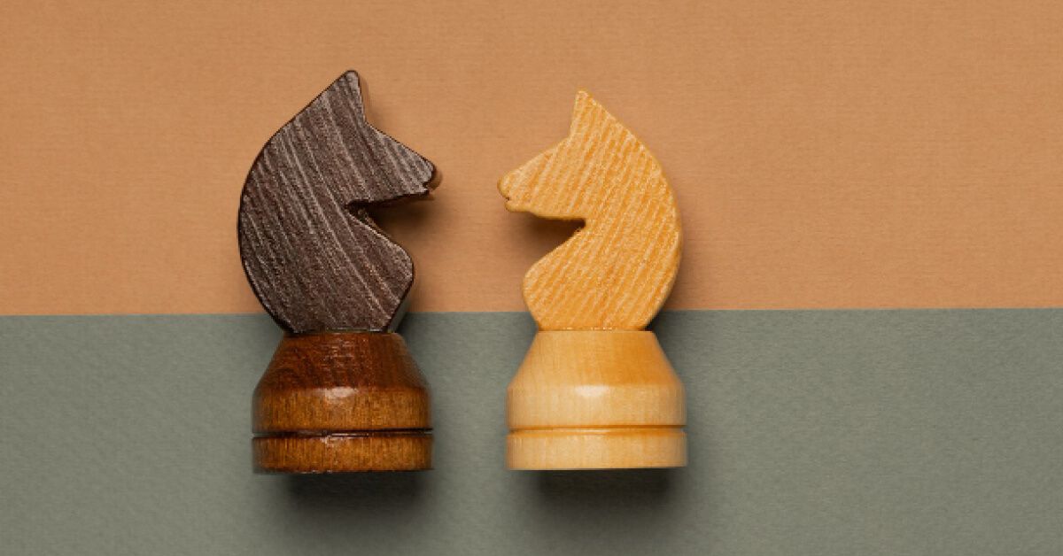 Black and white chess pieces facing each other