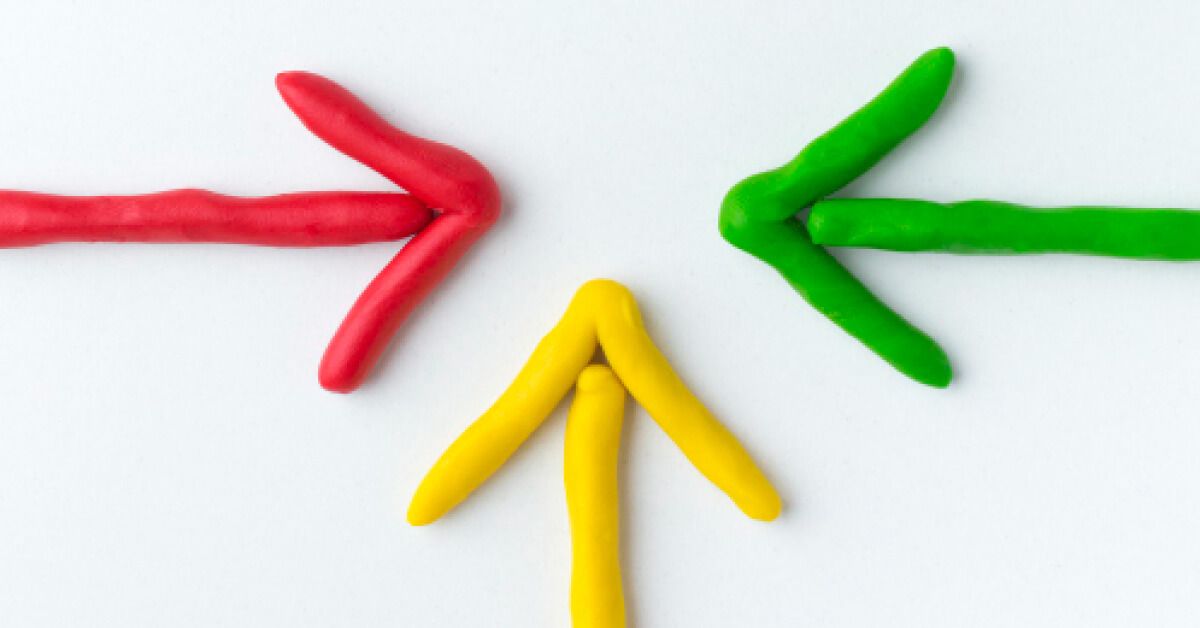Three arrows made up of red, green and yellow clay materials pointing towards the center