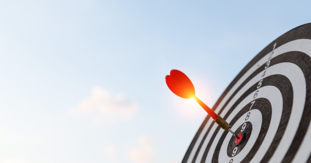 Red dart hitting the center of a target board