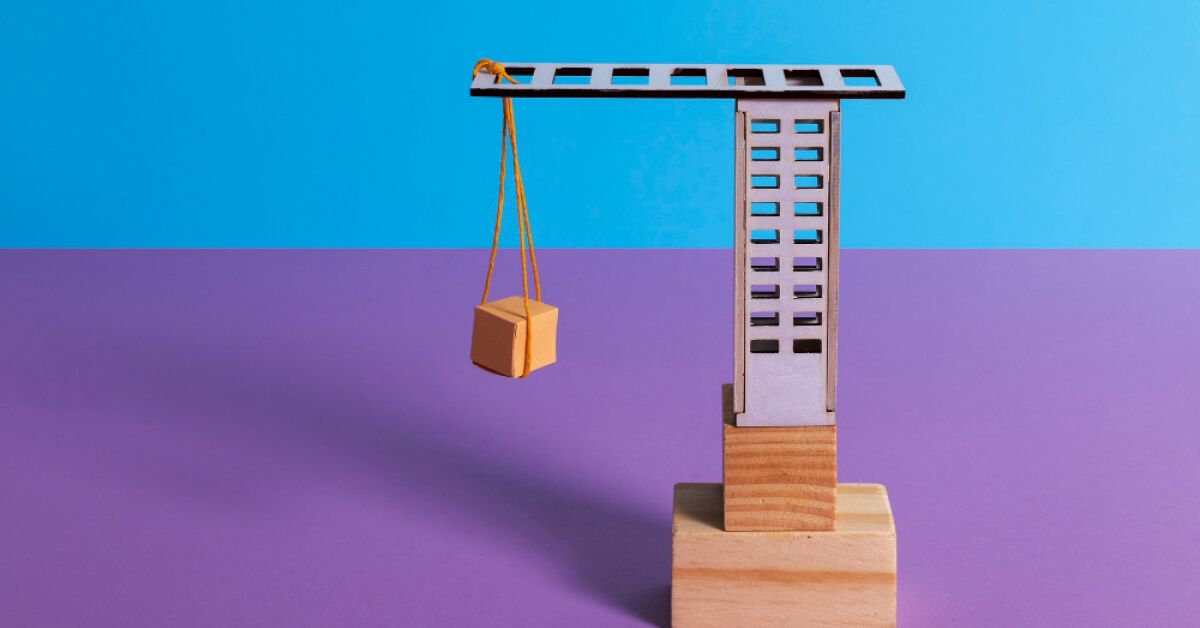 A toy crane setup made with wooden blocks and cardboard