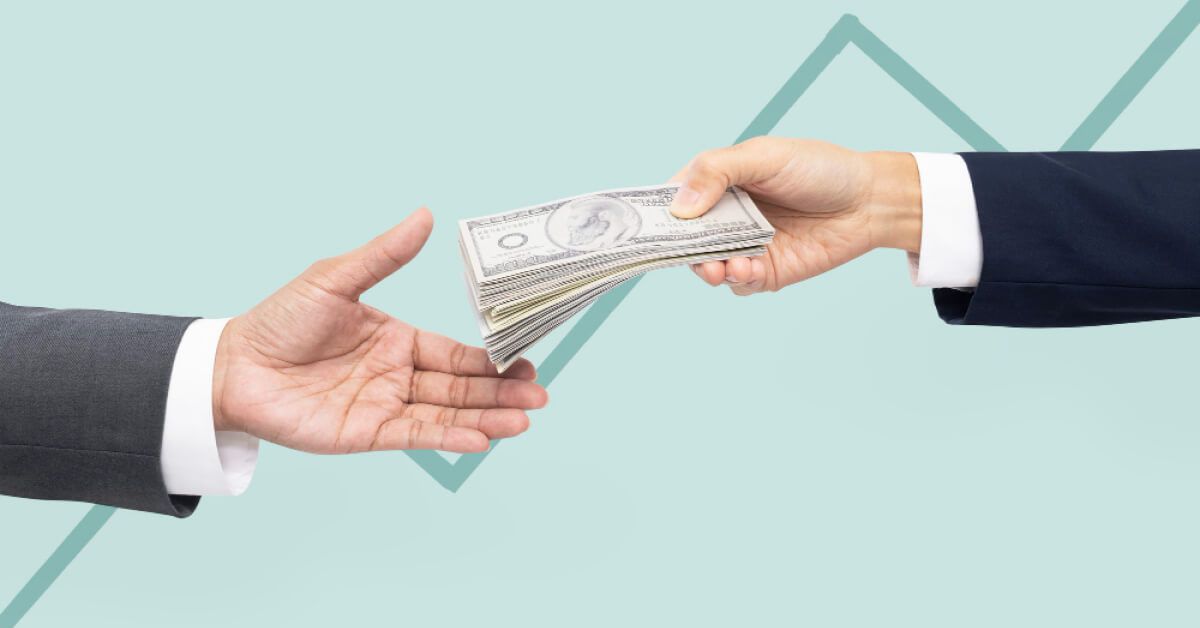 A human hand giving cash to another