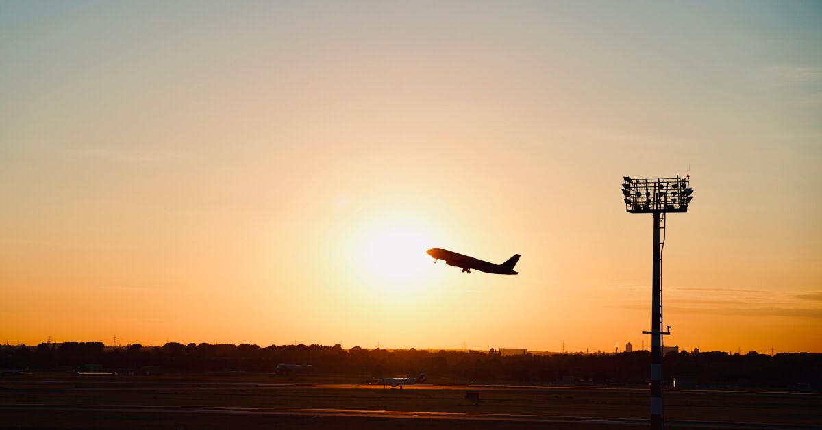 Silhouette of a plane leaving an airfield