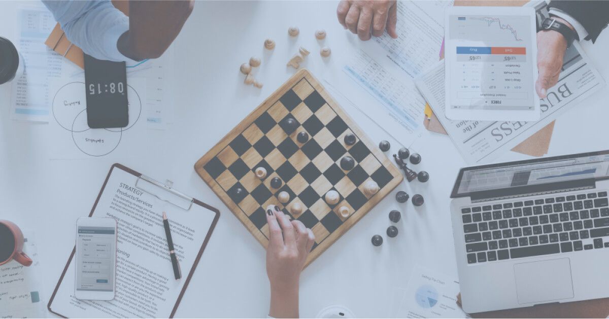 People playing chess on top of a workdesk