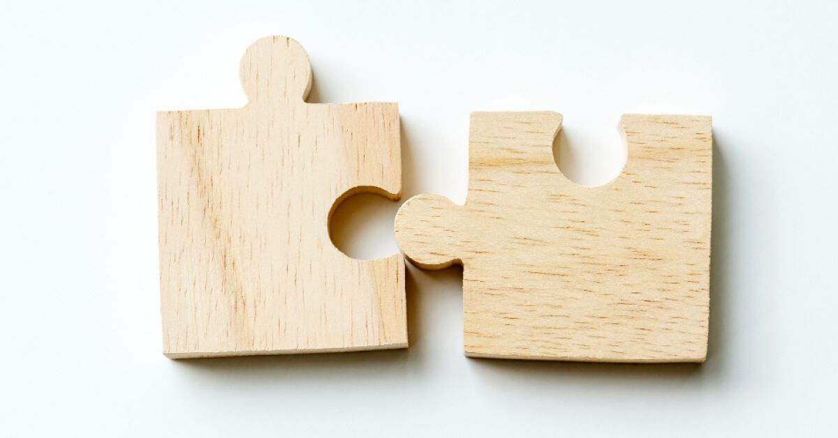 Two wooden puzzle pieces next to each other