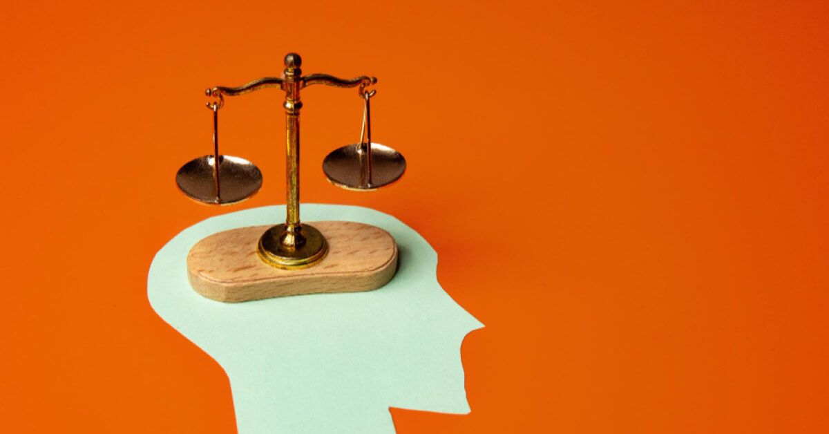 A balancing scale over a cutout of a person