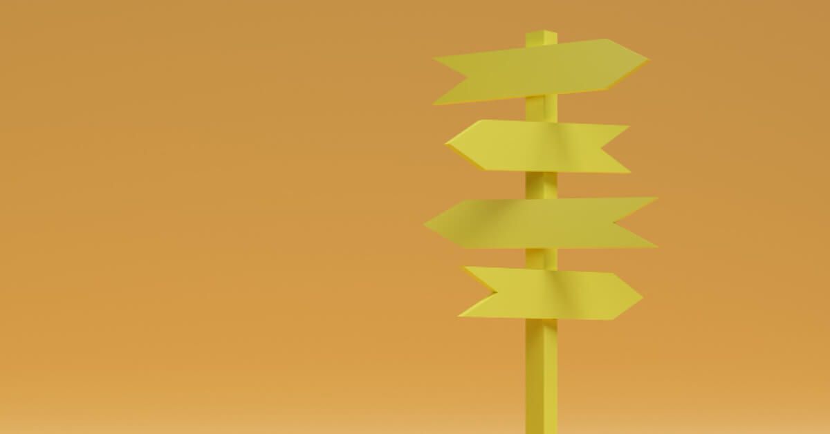Yellow direction pole with boards pointing in multiple directions